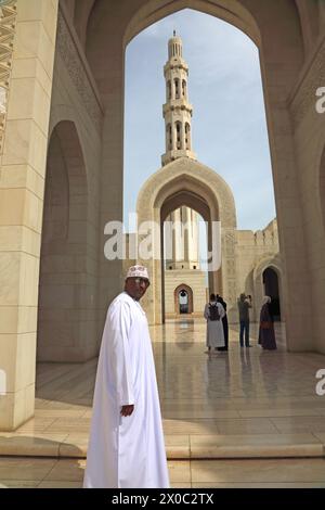 Sultan Qaboos Grande Mosquée omanaise portant un Dishdasha et Kummah par Archway et Minaret Muscat Oman Banque D'Images