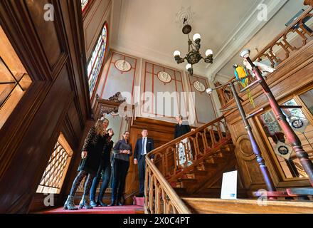 11 avril 2024, Brandebourg, Cottbus : les invités se tiennent dans l'escalier restauré du Palais Branitz au Parc du Musée Prince Pückler et à la Fondation du Palais Branitz (SFPM). Prince Pückler est connu comme un artiste de jardin, gastronomique et voyageur du monde entier. Cependant, l'amateur d'art était aussi un fan de couleur et de décoration. Il aimait présenter la précieuse décoration intérieure de son palais Branitz à ses invités. Après un an et demi de travaux de restauration, l’escalier avec ses précieux vitraux, vestibule et armurerie a été inauguré jeudi. La restauration a été financée par l'Ostdeutsche Sparkassenstiftung Banque D'Images