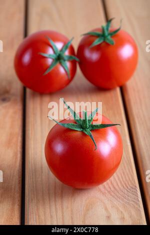 Un groupe de tomates rouges sur une table en bois Banque D'Images