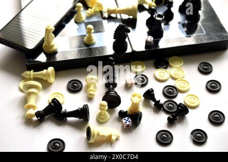 L'image montre une table et un échiquier sur lesquels reposent mélangés des pièces d'échecs oubliées. Banque D'Images