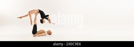 Une femme et un homme font preuve d'un équilibre impressionnant en faisant de l'élément acrobatique. Banque D'Images