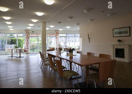 Hambourg, Allemagne. 11 avril 2024. Vue dans une salle à manger et de loisirs d'une installation pour les sans-abri ayant besoin de soins lors d'une séance photo avant l'ouverture. À partir du 22 avril 2024, la société municipale Fördern & Wohnen AöR ouvrira un centre pour les sans-abri gravement malades ayant besoin de soins au nom de l’autorité de protection sociale. Auparavant, les sans-abri ayant des restrictions sanitaires sévères à extrêmement sévères seront pris en charge dans l'ancienne maison de retraite. Crédit : Christian Charisius/dpa/Alamy Live News Banque D'Images