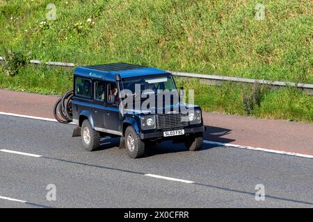 2003 Bleu Land Rover Defender 110 TD5 XS ; véhicule utilitaire sport circulant sur l'autoroute M6, Royaume-Uni Banque D'Images