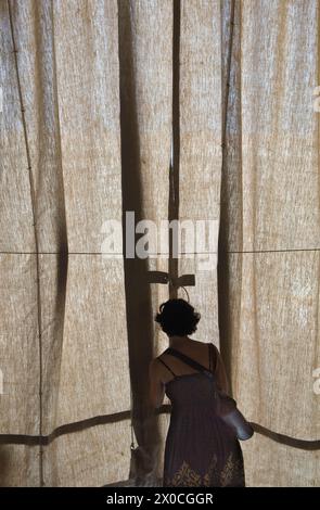 Silhouette de femme touriste contre les rideaux de crème solaire, qui protège les restaurants de café contre trop de lumière directe du soleil. Elle regarde la place Saint-Marc. Piazza San Marco. Années 2009 2000 Venise Italie HOMER SYKES Banque D'Images