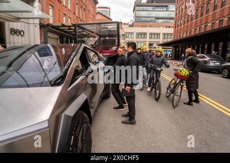 Les passionnés d'automobile ogleTesla Cybertrucks exposés devant le showroom Tesla dans le quartier Meatpacking à New York le samedi 6 avril 2024. (© Richard B. Levine) Banque D'Images