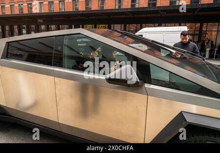 Les passionnés d'automobile ogleTesla Cybertrucks exposés devant le showroom Tesla dans le quartier Meatpacking à New York le samedi 6 avril 2024. (© Richard B. Levine) Banque D'Images