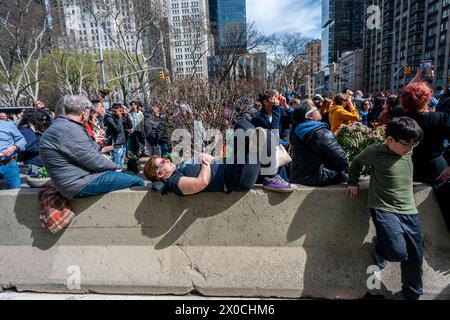 Des centaines de personnes se rassemblent à Flatiron Plaza à New York pour une fête d'observation à regarder, portant leurs lunettes de protection, l'éclipse solaire le lundi 8 avril 2024. New York City n'était pas sur le chemin de la totalité avec la lune couvrant 89% du soleil pendant la fenêtre de 15h15 à 15H30. (© Richard B. Levine) Banque D'Images