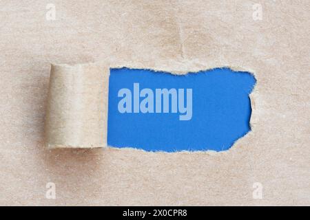 Papier brun déchiré avec fond bleu. Banque D'Images