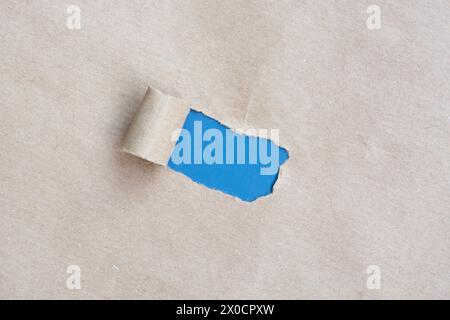 Papier brun déchiré avec fond bleu. Banque D'Images