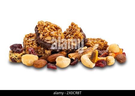 Cacahuètes maison croustillantes, amandes et mini barres protéinées au chocolat sur pile de fruits mélangés et de noix isolées sur fond blanc avec chemin de découpage. Banque D'Images