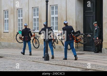 Les gardes du palais retirent les vélos sans surveillance avant la relève de la garde au palais d'Amalienborg Copenhague Danemark avril 2024 Banque D'Images