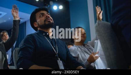 Des travailleurs de la presse multiethniques sont assis dans la salle de conférence. Journaliste indien lève la main, pose des questions et écrit la réponse pendant la campagne de presse avec un représentant de l'organisation ou un politicien. Banque D'Images