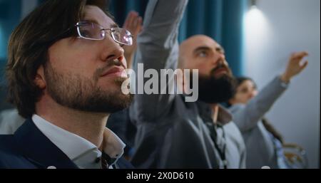 Divers journalistes lèvent la main à la campagne de presse dans la salle de conférence. Les travailleurs de la presse posent des questions, écoutent et écrivent le discours d'un activiste ou d'un politicien dans des cahiers lors d'entretiens avec les médias. Banque D'Images