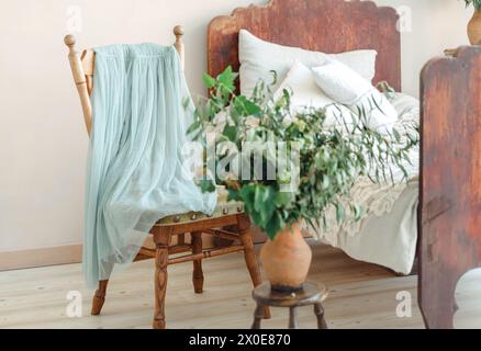 Une chambre contemporaine avec un lit, une chaise et une plante en pot disposés soigneusement dans la chambre. Banque D'Images