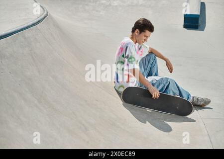 Un jeune homme profondément concentré alors qu'il est assis sur son skateboard glissant à travers un parc de skate dynamique par une journée d'été ensoleillée. Banque D'Images