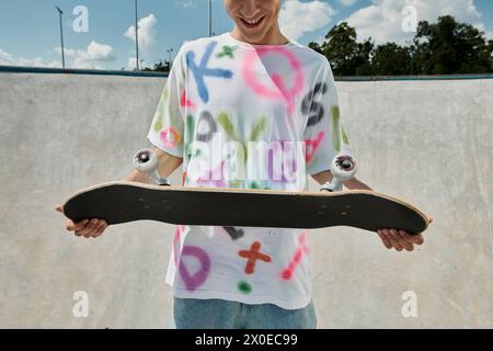 Un jeune homme avec une planche à roulettes dans un parc de skate dynamique, capturant l'essence de la liberté et de l'adrénaline tout en patinant à l'extérieur en été. Banque D'Images