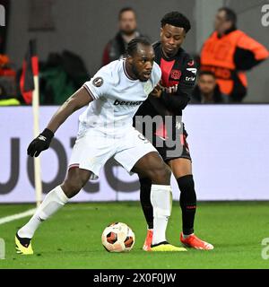 Leverkusen, Allemagne. 11 avril 2024. Nathan Tella (R) du Bayer 04 Leverkusen affronte Michail Antonio du West Ham United FC lors du match des quarts de finale de l'UEFA Europa League entre le Bayer 04 Leverkusen et le West Ham United FC à Leverkusen, Allemagne, le 11 avril 2024. Crédit : Ulrich Hufnagel/Xinhua/Alamy Live News Banque D'Images