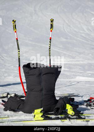 Attitash Mountain Resort, Bartlett, NH, États-Unis. Une veste d'échauffement Racers est à l'envers dans la neige avec des skis et des bâtons près de l'arrivée d'une course de ski alpin de slalom géant en février 2024 à Bear Peak. Banque D'Images