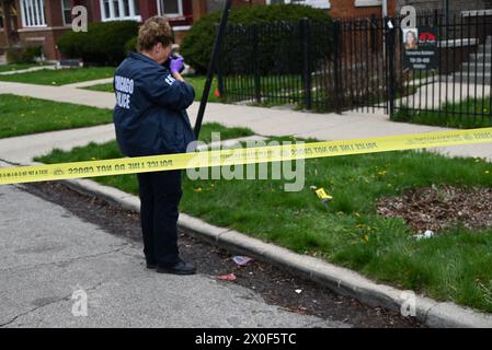 Un policier de Chicago prend des photos de douilles d'obus au sol, d'une arme à feu découverte au sol et d'un véhicule frappé par des coups de feu sur la scène du crime. Homme de 20 ans abattu par une autre personne et placé en détention par la police à Chicago, Illinois, États-Unis le 11 avril 2024. Jeudi après-midi vers 14h17, dans le bloc 1500 de l’avenue N. Leclaire, un homme de 20 ans a été découvert pour avoir subi une blessure par balle à la jambe droite après avoir été impliqué dans un échange de coups de feu avec un inconnu. La victime a été transportée à l'hôpital en bon état Banque D'Images