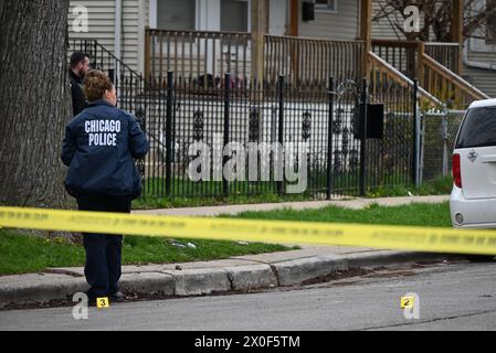 Un policier de Chicago prend des photos de douilles d'obus au sol, d'une arme à feu découverte au sol et d'un véhicule frappé par des coups de feu sur la scène du crime. Homme de 20 ans abattu par une autre personne et placé en détention par la police à Chicago, Illinois, États-Unis le 11 avril 2024. Jeudi après-midi vers 14h17, dans le bloc 1500 de l’avenue N. Leclaire, un homme de 20 ans a été découvert pour avoir subi une blessure par balle à la jambe droite après avoir été impliqué dans un échange de coups de feu avec un inconnu. La victime a été transportée à l'hôpital en bon état Banque D'Images