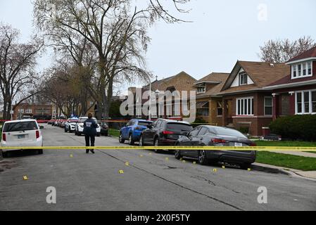 Un policier de Chicago prend des photos de douilles d'obus au sol, d'une arme à feu découverte au sol et d'un véhicule frappé par des coups de feu sur la scène du crime. Homme de 20 ans abattu par une autre personne et placé en détention par la police à Chicago, Illinois, États-Unis le 11 avril 2024. Jeudi après-midi vers 14h17, dans le bloc 1500 de l’avenue N. Leclaire, un homme de 20 ans a été découvert pour avoir subi une blessure par balle à la jambe droite après avoir été impliqué dans un échange de coups de feu avec un inconnu. La victime a été transportée à l'hôpital en bon état Banque D'Images