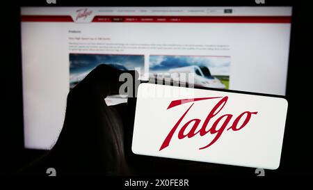 Personne tenant un smartphone avec le logo de la société espagnole de fabrication de trains Talgo S.A. en face du site Web. Concentrez-vous sur l'affichage du téléphone. Banque D'Images