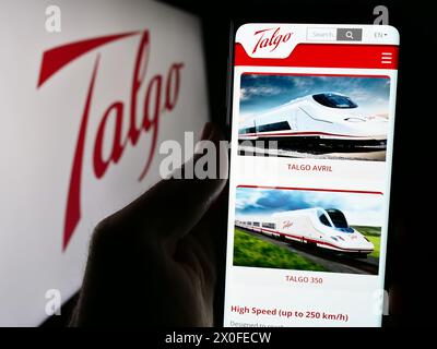 Personne tenant le téléphone portable avec la page Web de la société espagnole de fabrication de train Talgo S.A. devant le logo. Concentrez-vous sur le centre de l'écran du téléphone. Banque D'Images