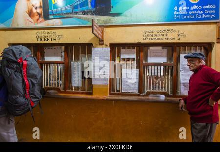 Ambewela, Sri Lanka - 28 janvier 2024 : voyageurs aux guichets avec les horaires affichés et des informations à la gare d'Ambewela. Banque D'Images