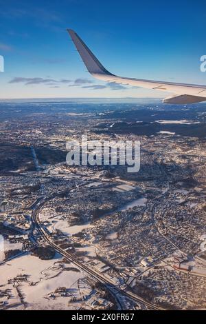 Avion volant bas au-dessus de montagnes enneigées et se préparant à atterrir à l'aéroport, vue depuis la fenêtre de l'avion de la turbine d'aile et de l'horizon Banque D'Images