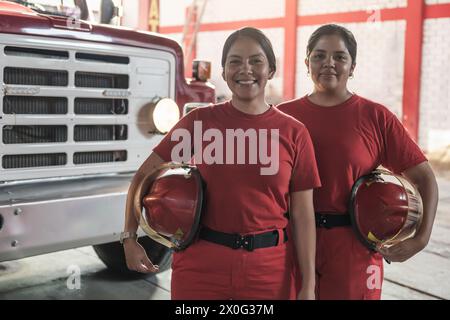 Portrait de pompiers femmes heureuses debout à la caserne de pompiers Banque D'Images