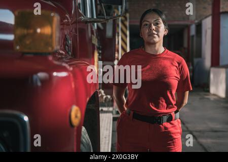 Portrait de pompier féminin souriant debout à la caserne de pompiers Banque D'Images