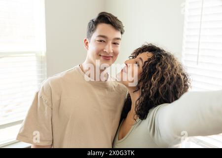 Couple souriant partage un selfie proche et tendre Banque D'Images