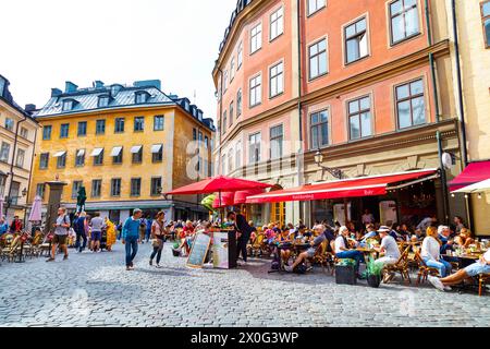 Les gens assis dehors dans les cafés et restaurants de la place Jarntorget à Gamla Stan (vieille ville), Stockholm, Suède Banque D'Images