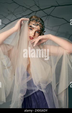 Une jeune femme dans une robe avec un voile ornant sa tête ressemble à une princesse fée dans un décor fantastique. Banque D'Images