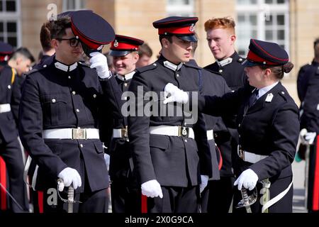 Officiers Cadets commissionnés en tant qu'officiers de l'armée se préparent dans le nouveau College Square avant le défilé du souverain à l'ancien collège de la Royal Military Academy Sandhurst (RMAS) à Camberley, Surrey. Le chef d'état-major de l'armée de terre en France représente le roi Charles III au défilé de la 120e année de la signature de l'Entente cordiale anglo-française. Date de la photo : vendredi 12 avril 2024. Banque D'Images