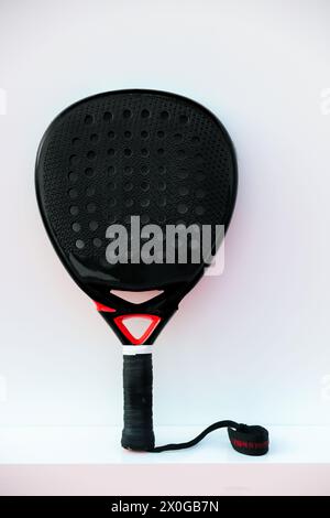 Raquette de tennis Padel professionnelle noire sur fond blanc. affiche verticale sur le thème du sport, cartes de vœux, site web et application Banque D'Images