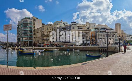 San Giljan, (Julian’s), Malte - 8 novembre 2020 : bateaux amarrés dans la baie de Spinola surplombant le Monument de l’amour et les appartements. Banque D'Images