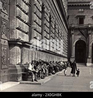 Vue sur une foule de personnes devant l'entrée du Residenz München. Les bancs sont densément occupés par des gens qui profitent du soleil de printemps. [traduction automatique] Banque D'Images