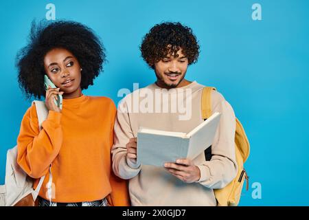 Un homme et une femme de races différentes se tenant ensemble dans un studio, mettant en valeur l’unité et la diversité. Banque D'Images
