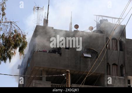 Un camion de pompier se déploie sous forme de flots de fumée depuis un bâtiment après un bombardement israélien à Nuseirat Un camion de pompier se déploie sous forme de flots de fumée depuis un bâtiment après un bombardement israélien à Nuseirat, dans le centre de Gaza, le 12 avril 2024, au milieu de batailles en cours entre Israël et le groupe militant palestinien Hamas. Le 12 avril, les autorités du territoire palestinien côtier dirigé par le Hamas ont signalé des dizaines de nouvelles frappes aériennes dans la région centrale de Gaza. Photo Naaman Omar apaimages Nusairat bande de Gaza territoire palestinien 120424 Nusairt Naa 1 004 Copyright : xapaimagesxNaamanxOmarxxxapaimagesx Banque D'Images