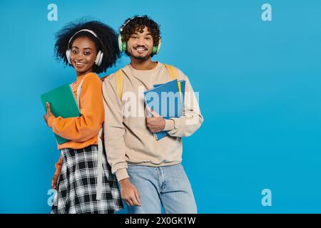 Un homme et une femme de différentes races debout ensemble dans une tenue décontractée, mettant en valeur l'unité et la diversité dans un cadre de studio. Banque D'Images