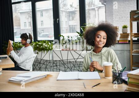 Une femme est assise à une table, savourant une tasse de café dans un cadre confortable. Banque D'Images