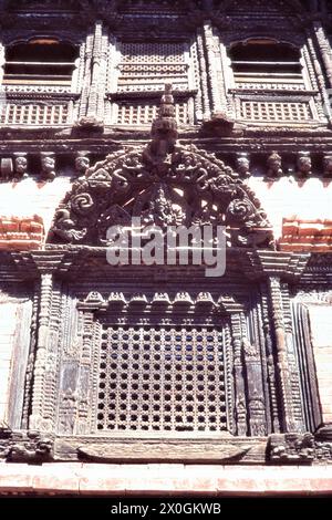 Fenêtres sculptées en bois avec de nombreux ornements au Palais Royal de Bhaktapur. [traduction automatique] Banque D'Images