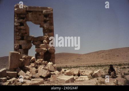 Un homme voilé est assis à côté du temple du feu près de la tombe du roi Cyrus à Pasargeadae. [traduction automatique] Banque D'Images