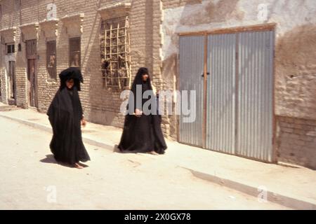 Deux femmes avec hijab et voile devant une façade de maison à Curbela. [traduction automatique] Banque D'Images