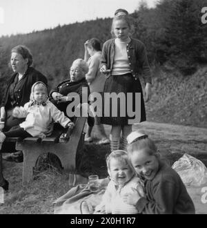 Deux grands-mères avec des enfants reposant sur un banc lors d'une excursion dans le Sauerland. Banque D'Images