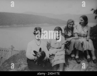 Mère et fille avec deux amies lors d'une sortie avec un chien au bord d'un lac (photo non datée). Banque D'Images