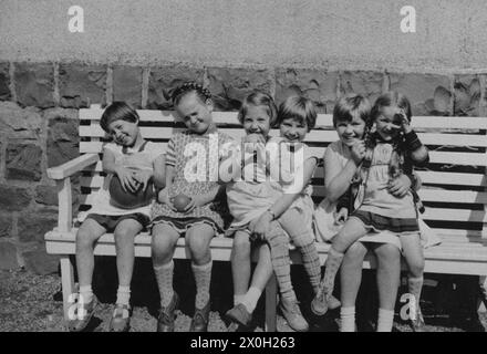 Enfants heureux avec des balles assis sur un banc dans le Sauerland (photo non datée). Banque D'Images