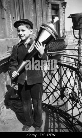 Un garçon avec un Schultuete (cône d'école) sur un balcon à Berlin. Banque D'Images