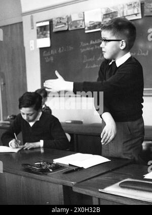 Enfants pendant les cours à l'école. La photo montre un garçon expliquant quelque chose à ses camarades de classe. [traduction automatique] Banque D'Images